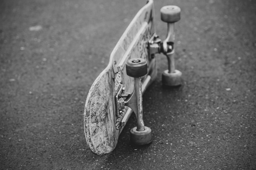 grayscale photo of skateboard on road