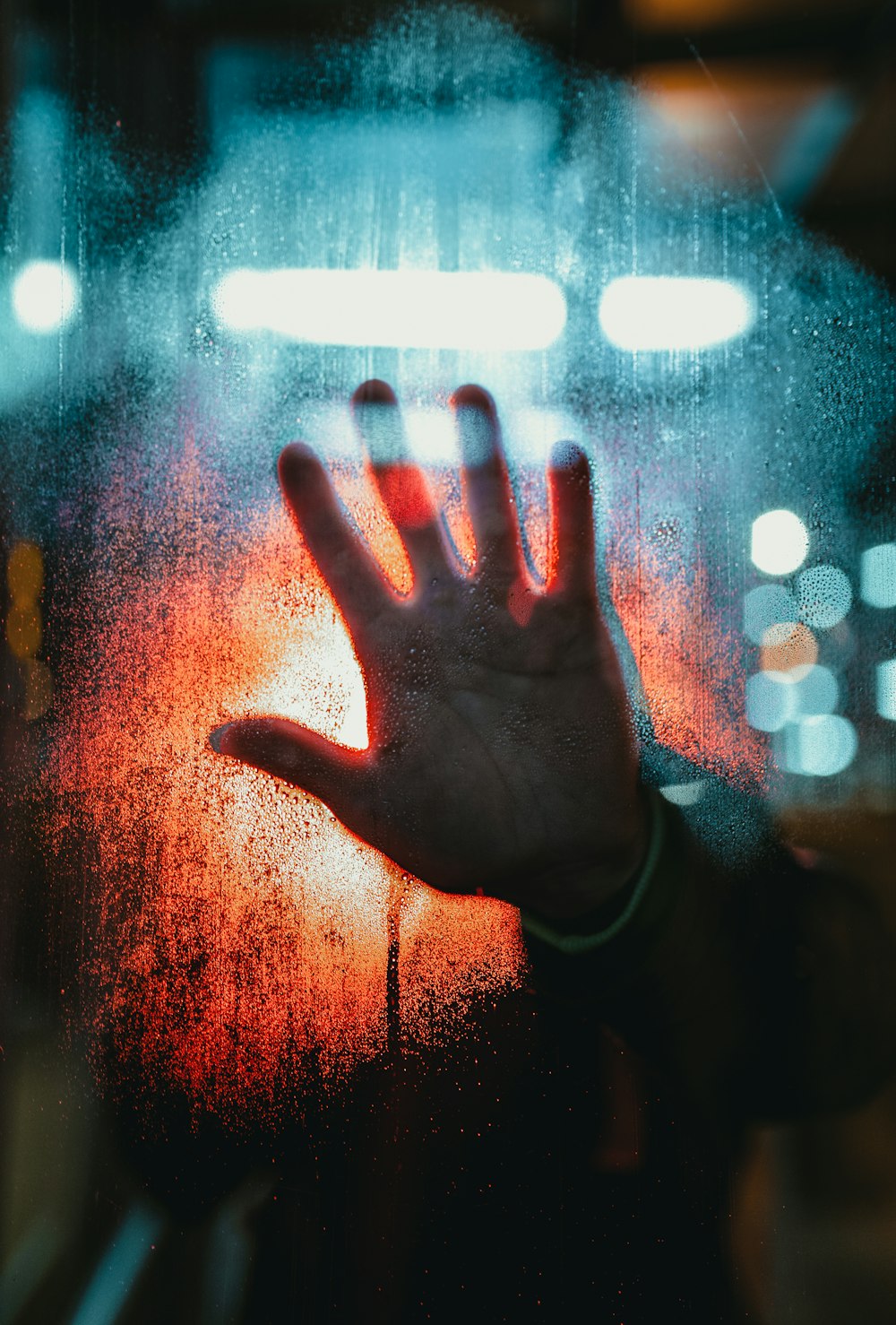 person in black long sleeve shirt with water droplets on glass