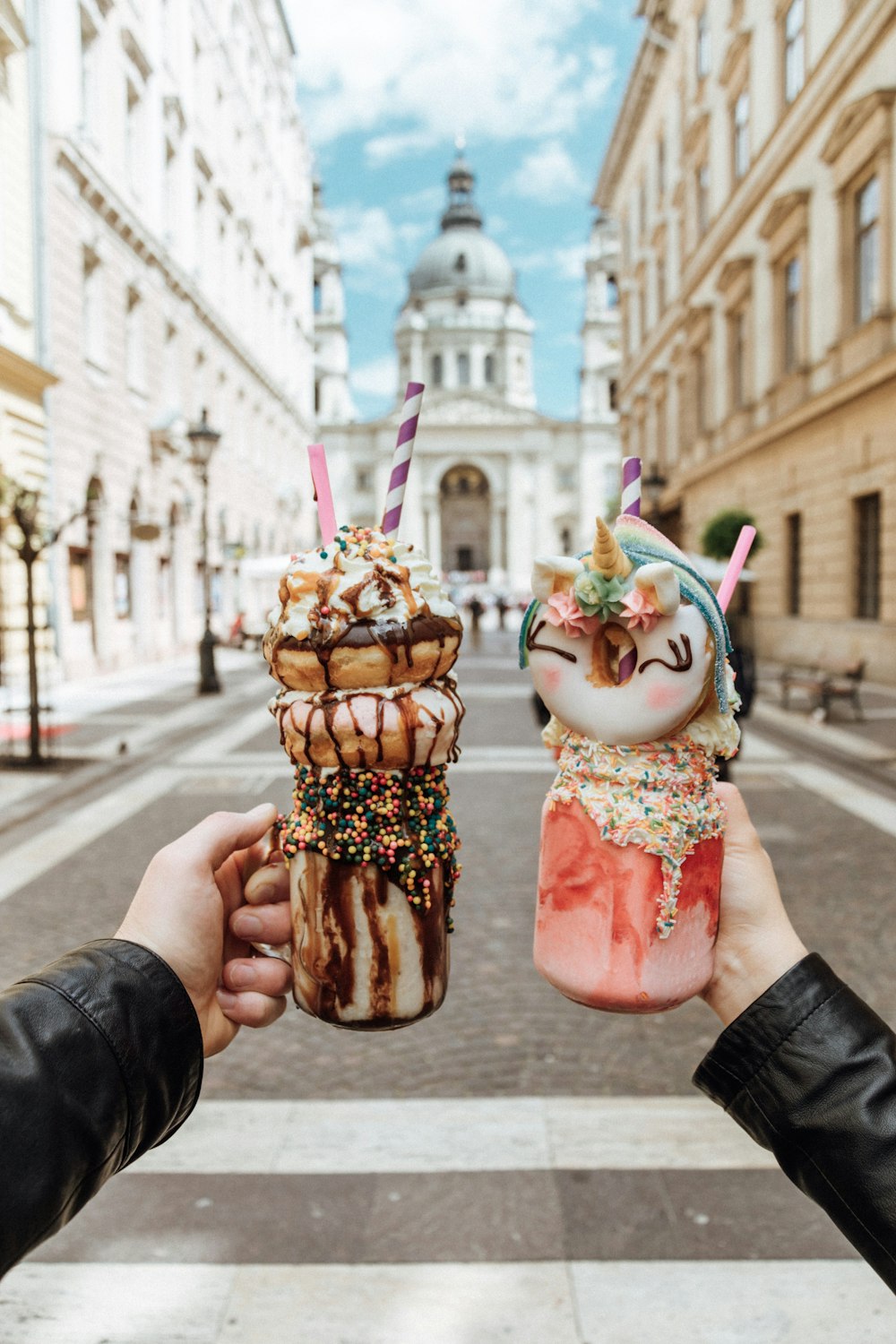 person holding ice cream cone with ice cream and cherry on top