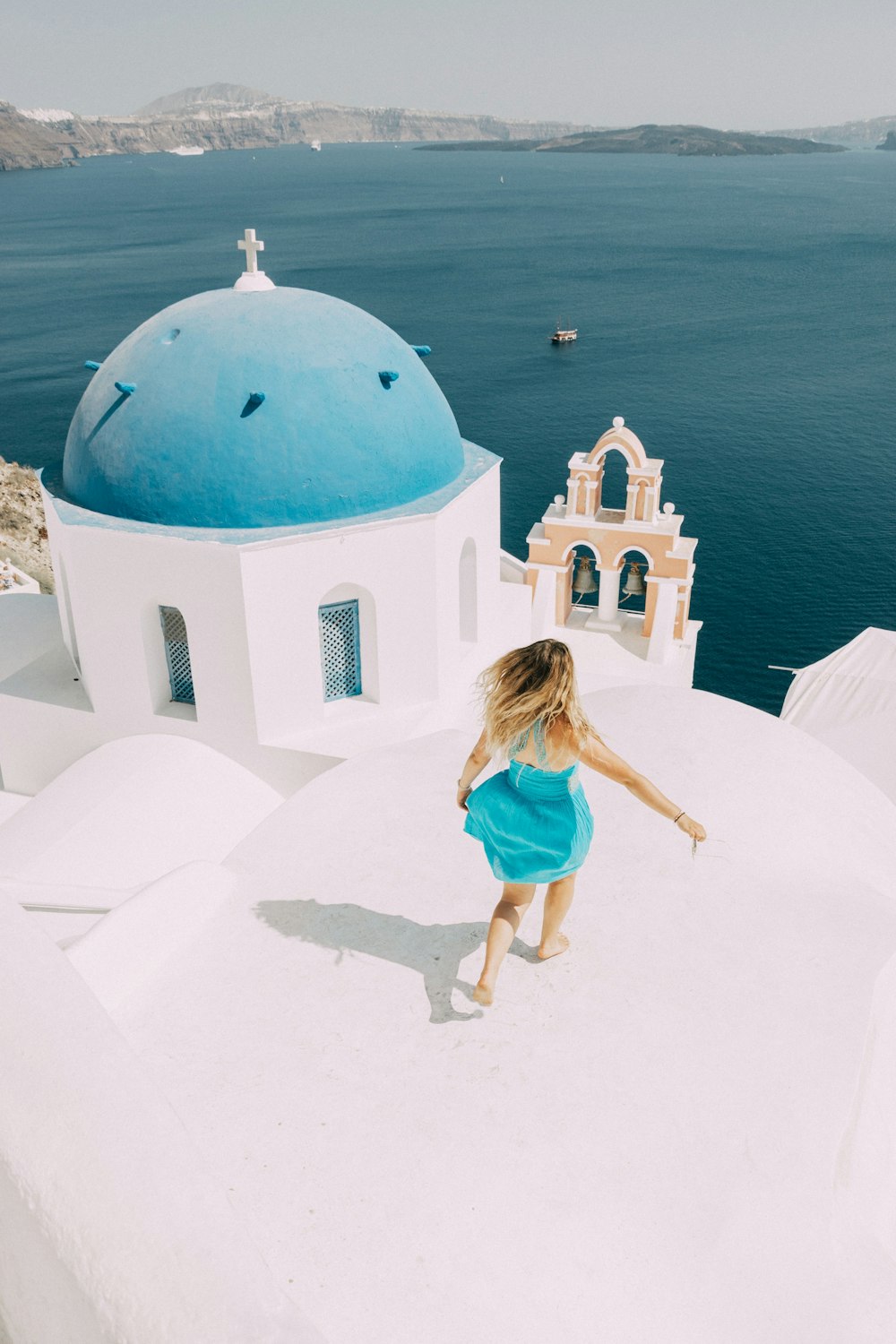 woman in blue dress standing on white concrete floor