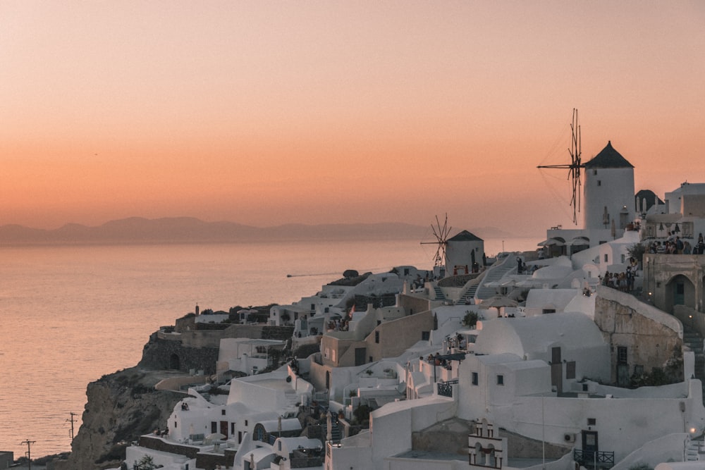 white concrete houses near body of water during sunset