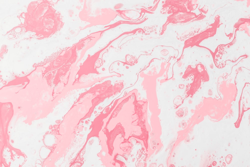 a close up of a pink and white marble background