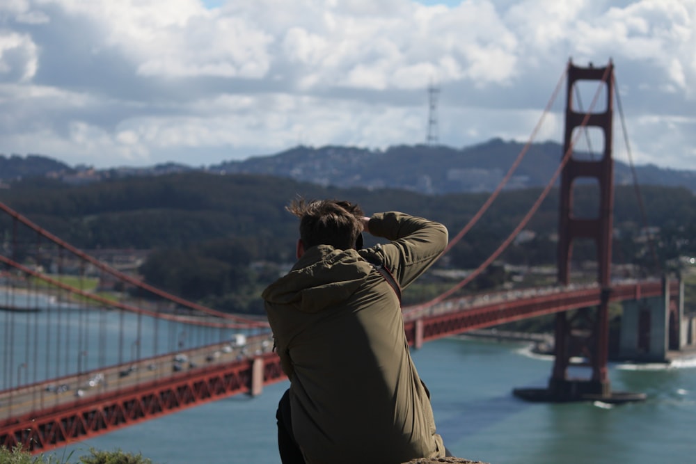 woman in brown jacket standing on bridge during daytime