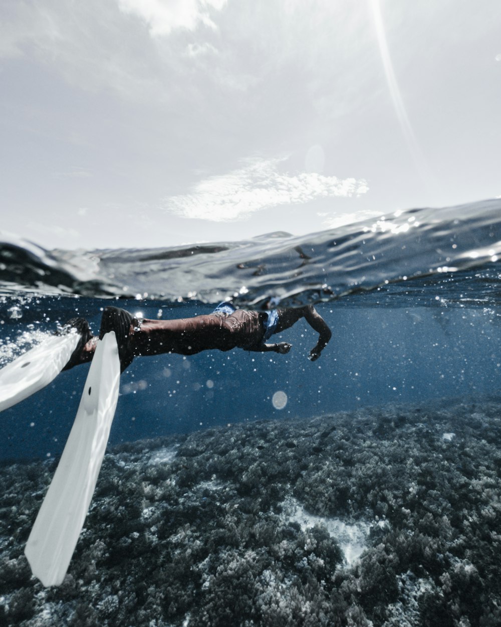 person in black shorts surfing on sea waves during daytime