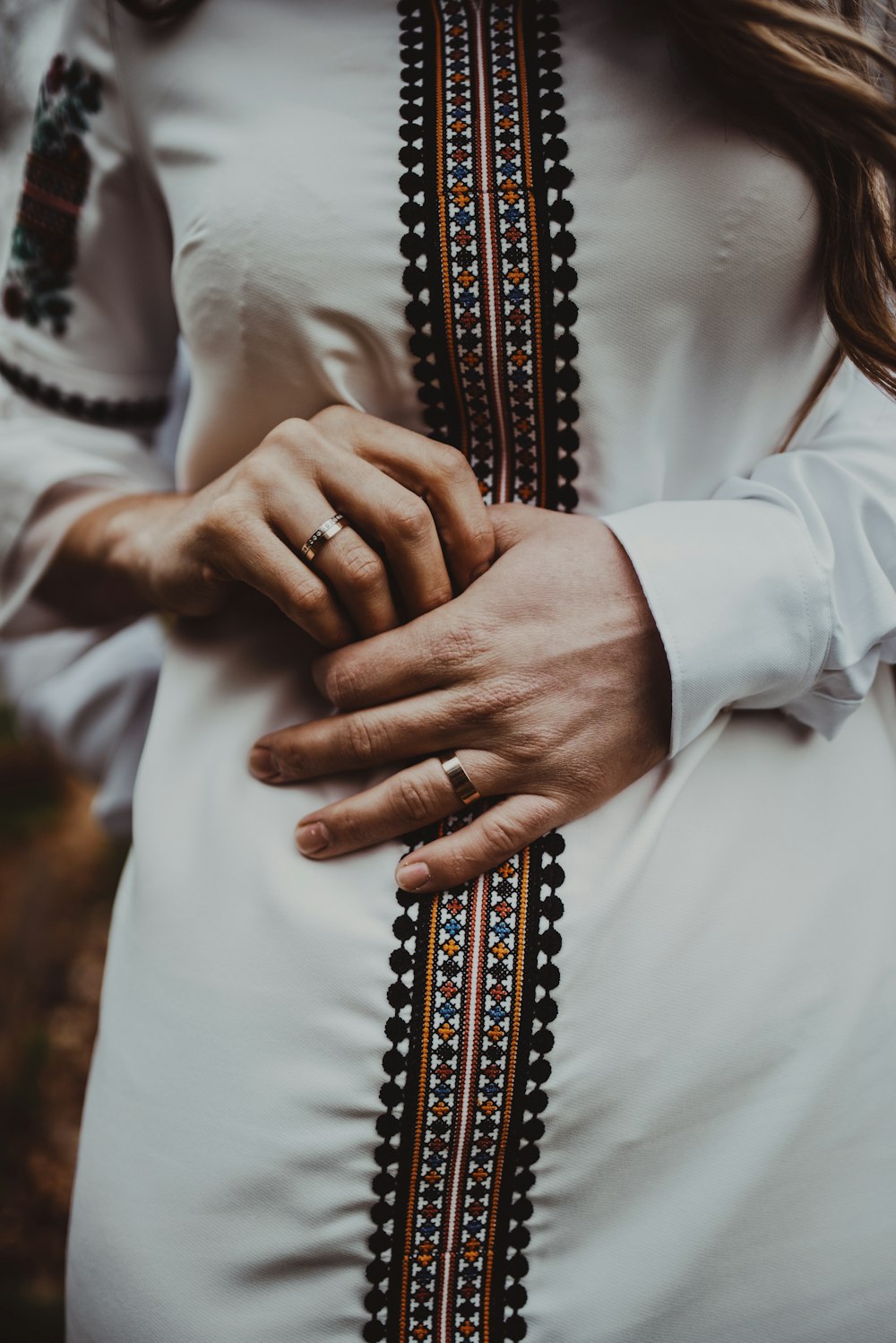 man in white dress shirt holding his black and white necktie