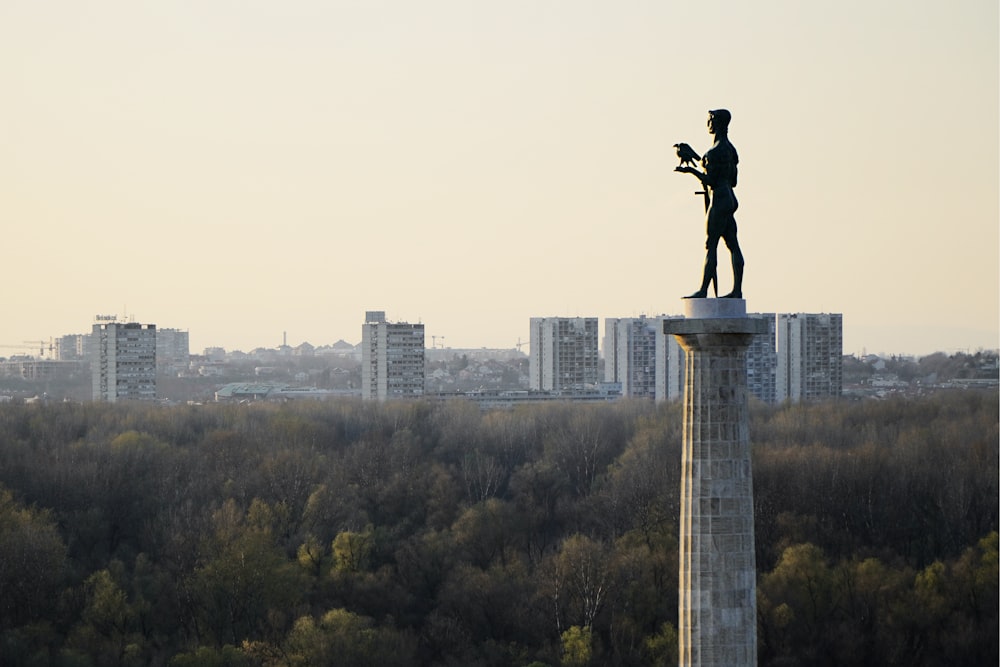 Statua dell'uomo che cavalca il cavallo vicino agli edifici della città durante il giorno