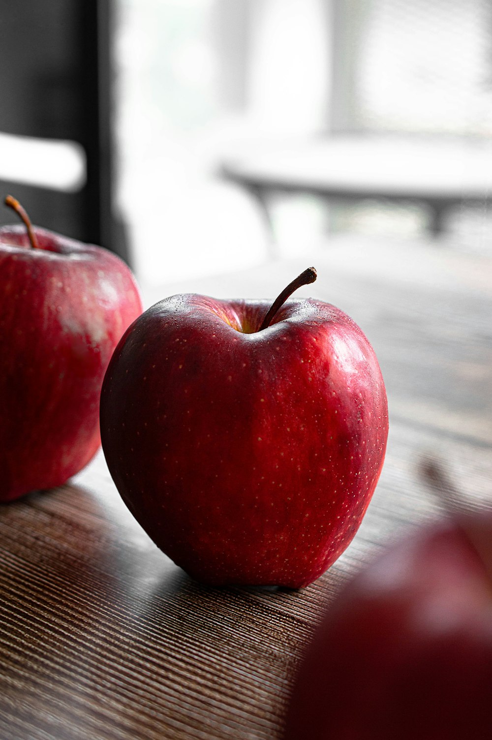 roter Apfel auf braunem Holztisch