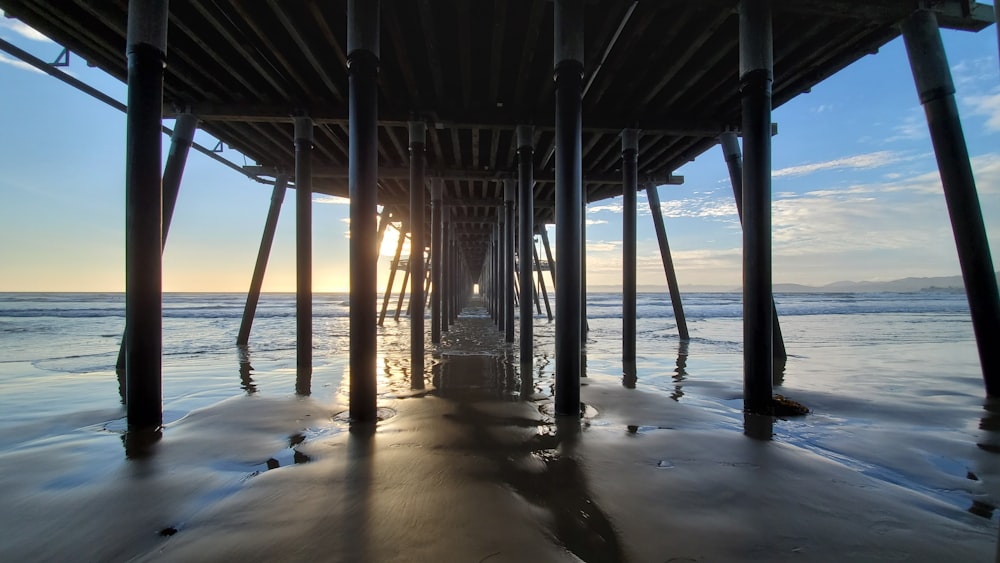 silhouette of dock on sea during sunset