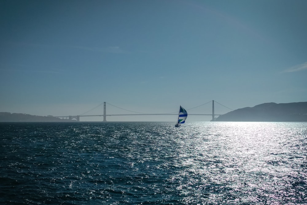 blue and yellow sail boat on sea during daytime