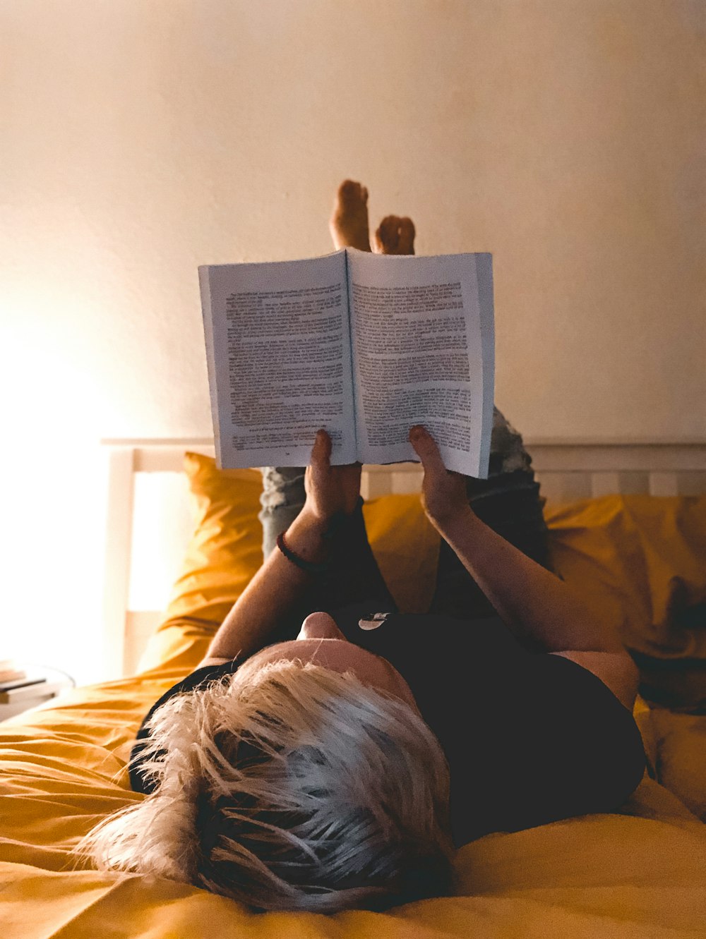 person reading book on bed