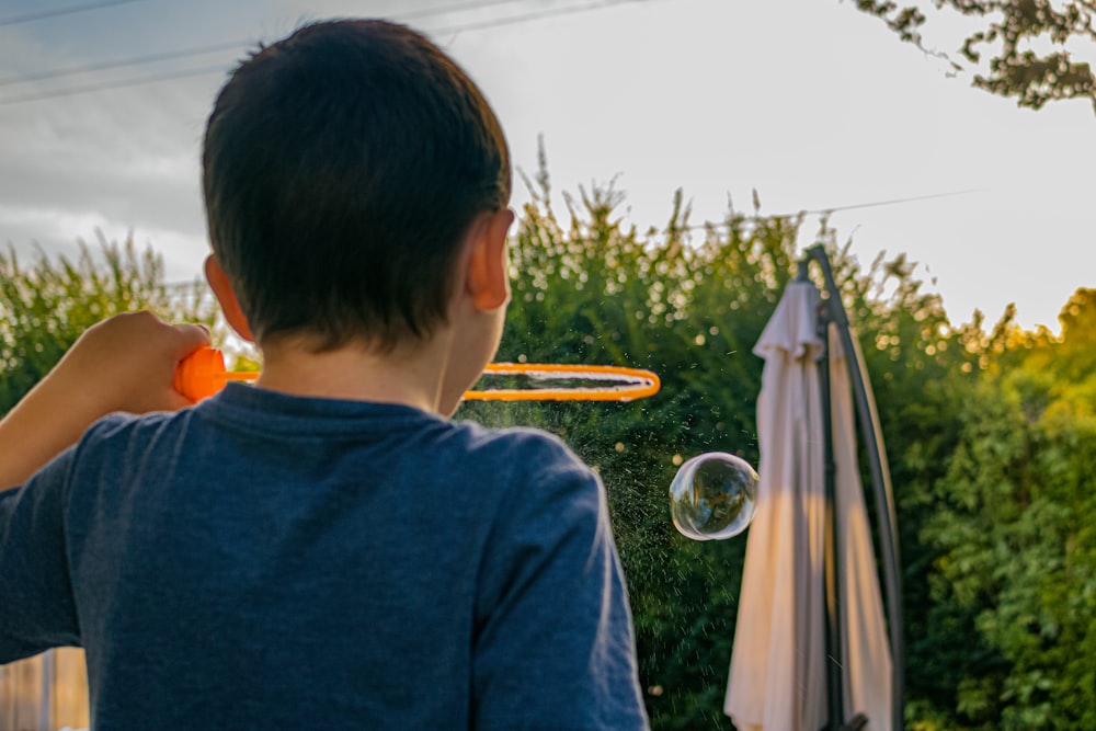 boy in blue shirt looking at the bubble