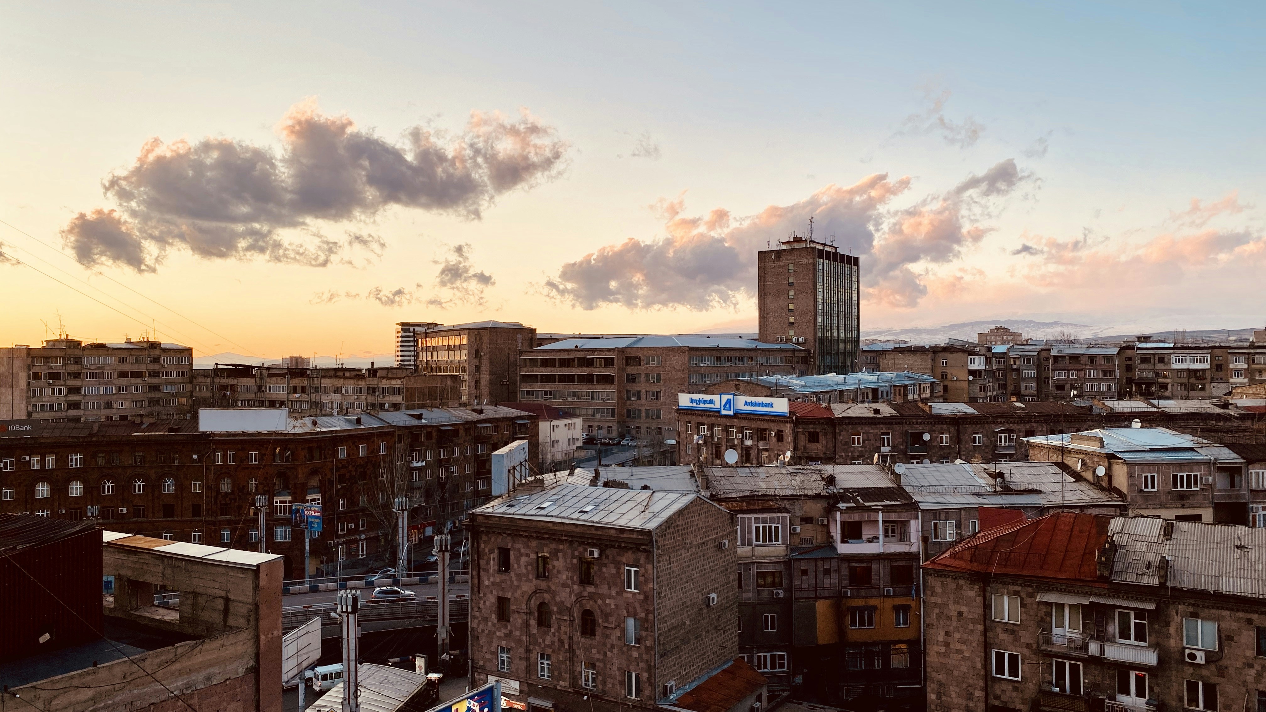 brown and white concrete buildings under cloudy sky during daytime armenia teams background