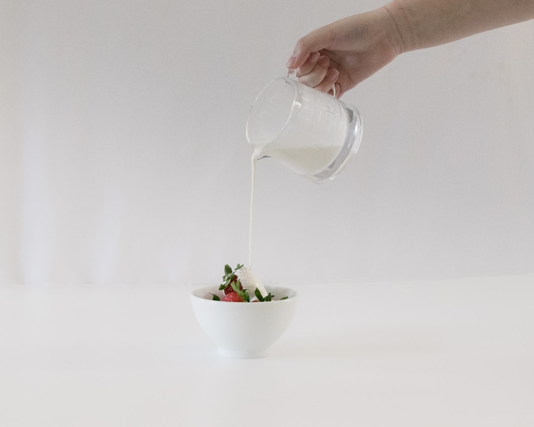 person pouring water on white ceramic bowl