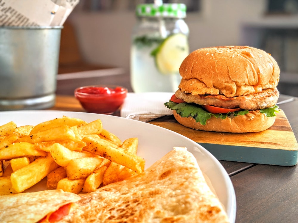 hamburger e patatine fritte su piatto di ceramica bianca