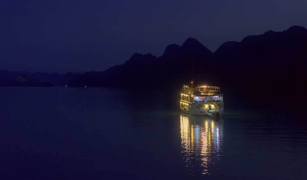 lighted building on body of water during night time