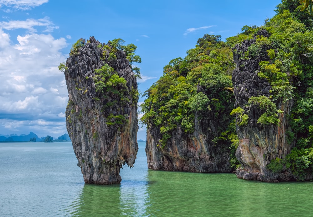 green and brown rock formation on blue sea under blue sky during daytime