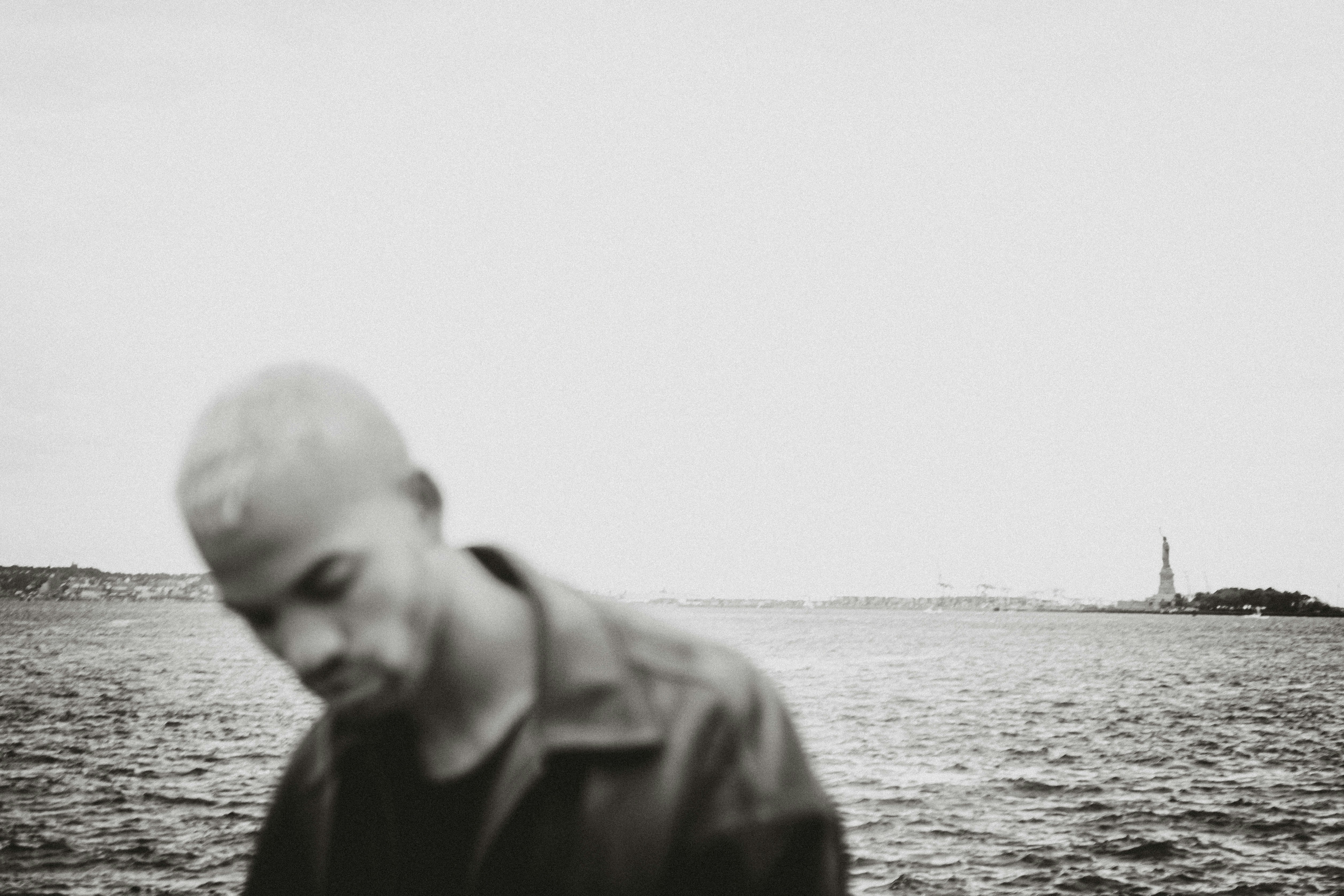 man in black jacket standing near body of water during daytime