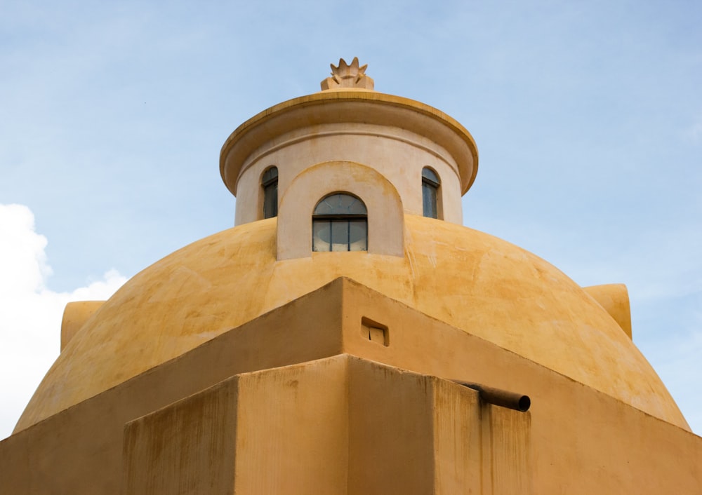 edificio in cemento marrone sotto il cielo blu durante il giorno