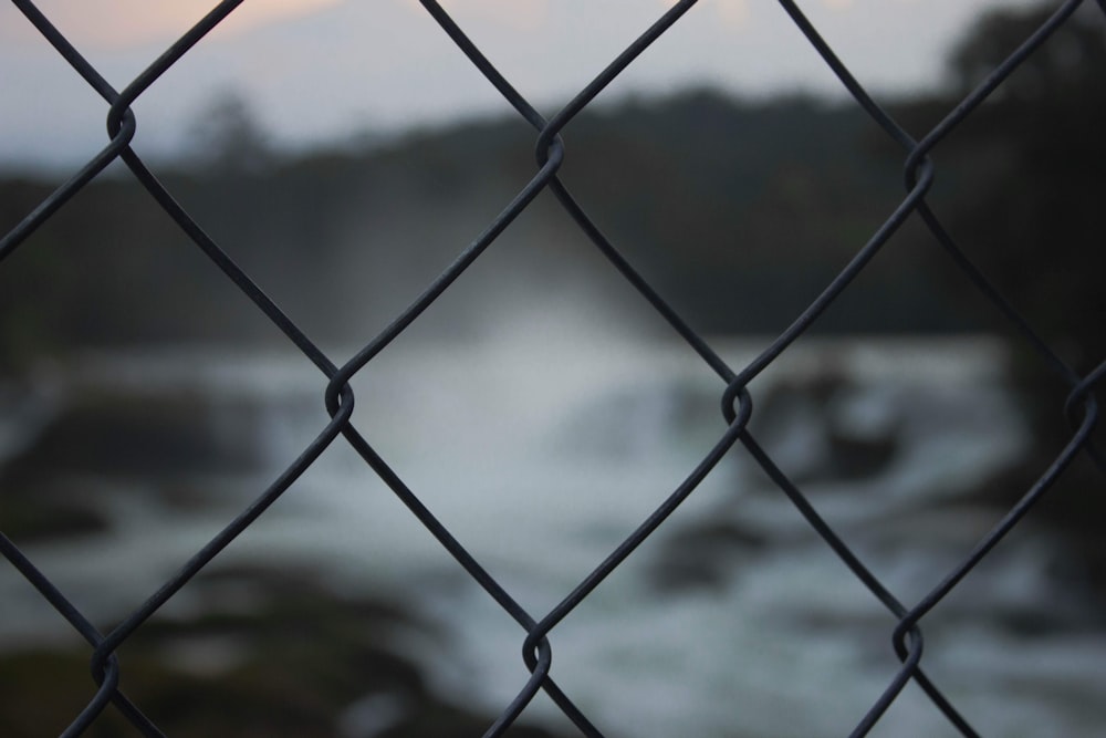 grey metal fence near body of water during daytime