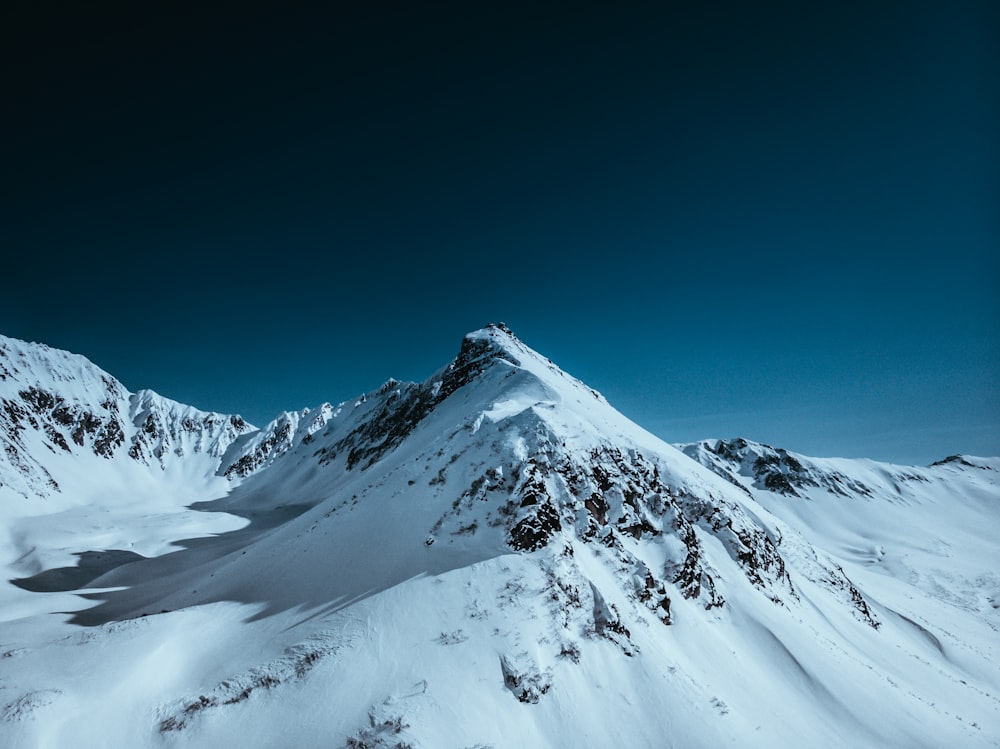 montanha coberta de neve sob o céu azul durante o dia