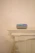 A cozy living room corner with soft natural light highlighting a sleek smart speaker on a wooden side table.