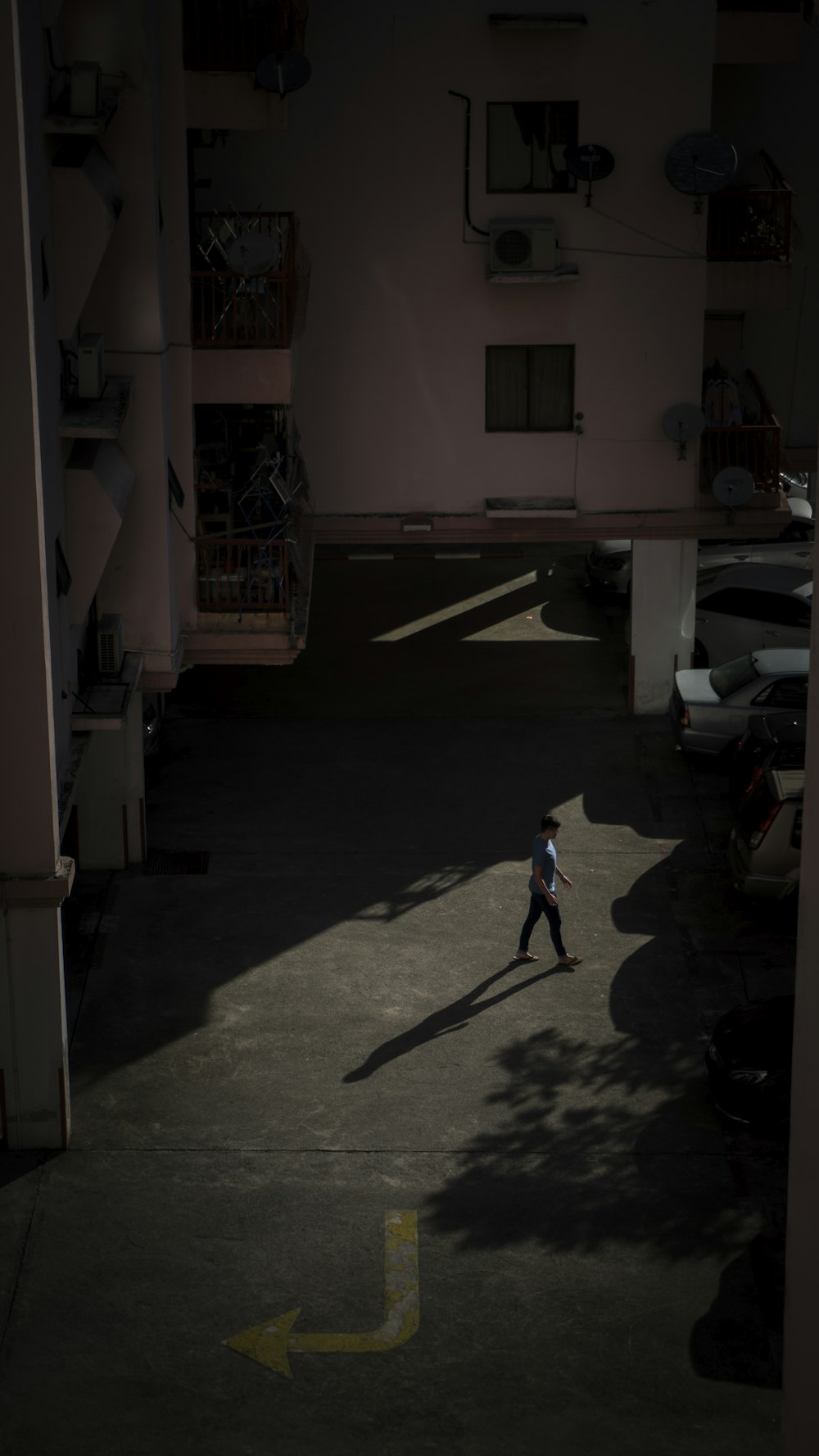 woman in blue shirt walking on street during daytime