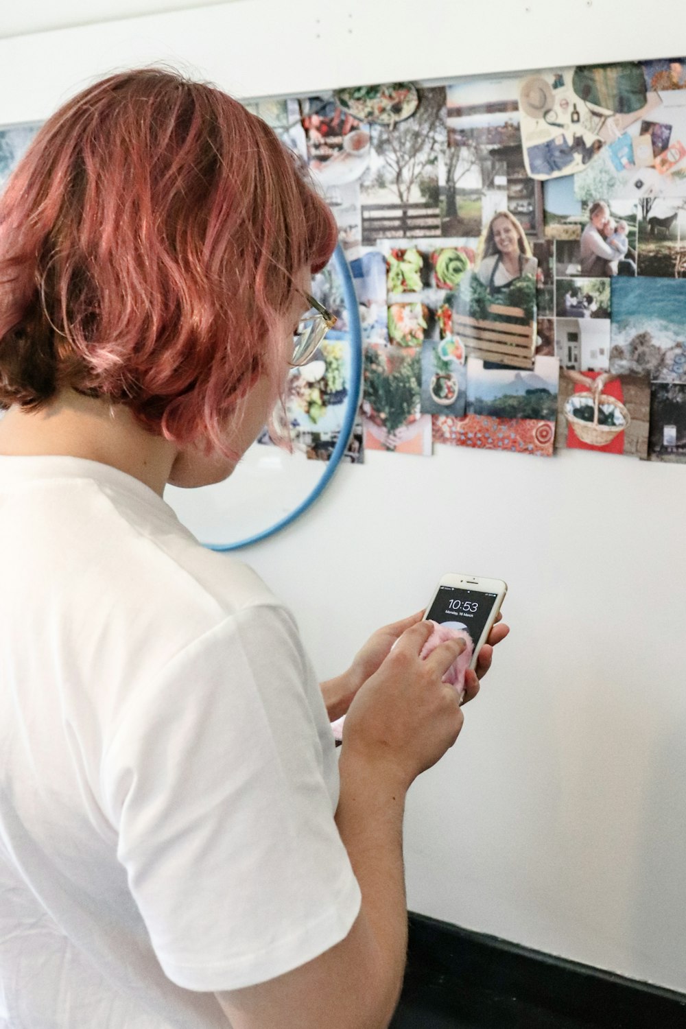 woman in white shirt holding black smartphone