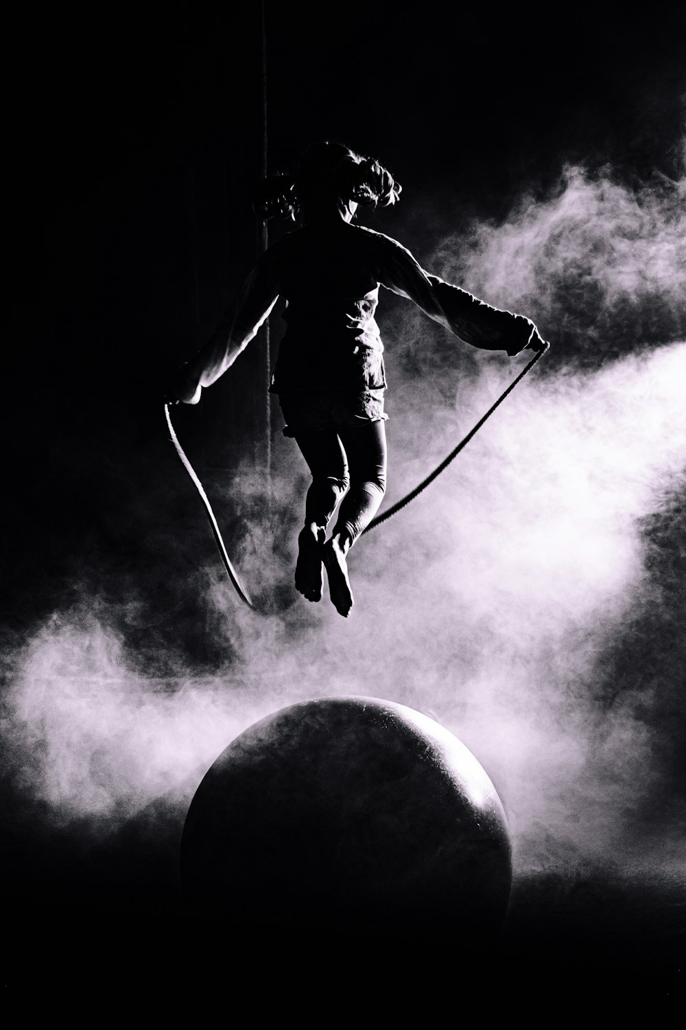 man in black jacket and pants with black backpack holding rope