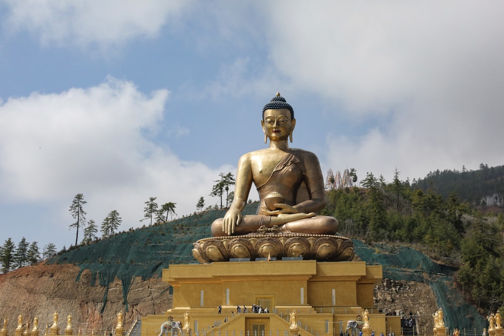 gold buddha statue under cloudy sky during daytime