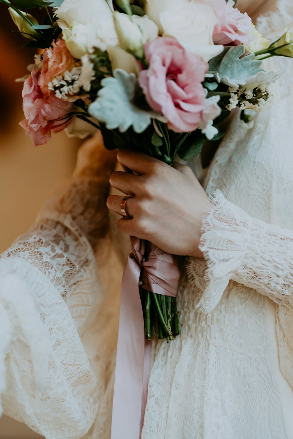 woman in white wedding dress holding white and pink flower bouquet