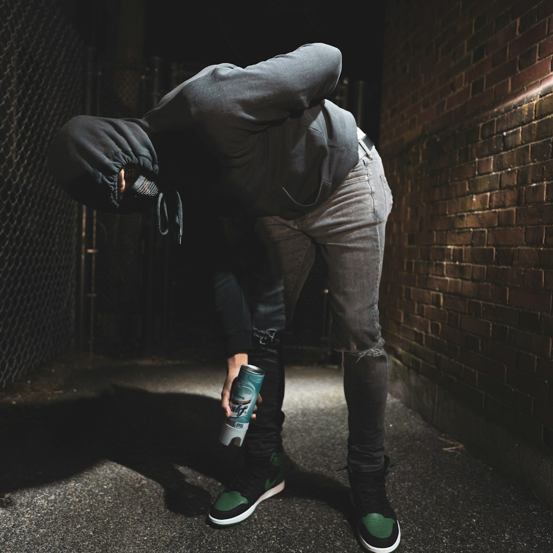 man in brown jacket and brown pants standing beside brick wall