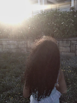 A candid moment of a child playing in a terracotta-colored garden bathed in golden sunlight.