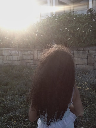 Portrait of a child playing in a sunlit garden with soft shadows