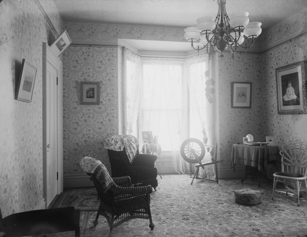 grayscale photo of armchair near window