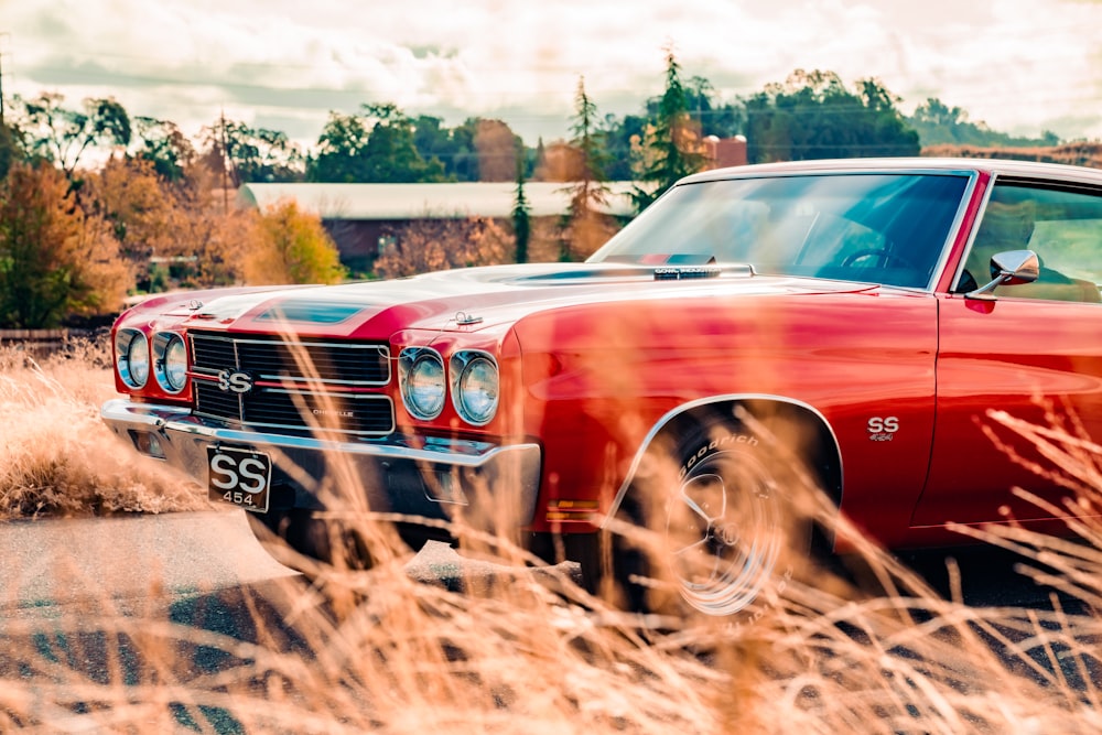 Coche rojo en camino de tierra marrón durante el día