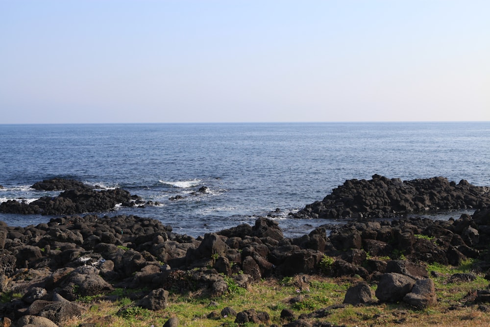 rocky shore with ocean waves crashing on rocks during daytime