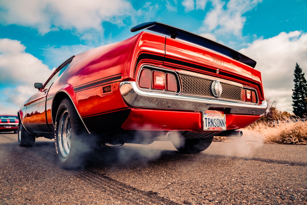 red chevrolet camaro on gray asphalt road during daytime