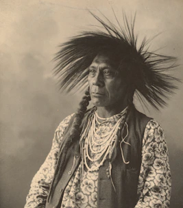 A serene portrait of a shaman in traditional attire against a dark, mystical background.