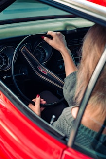 woman in gray sweater driving car