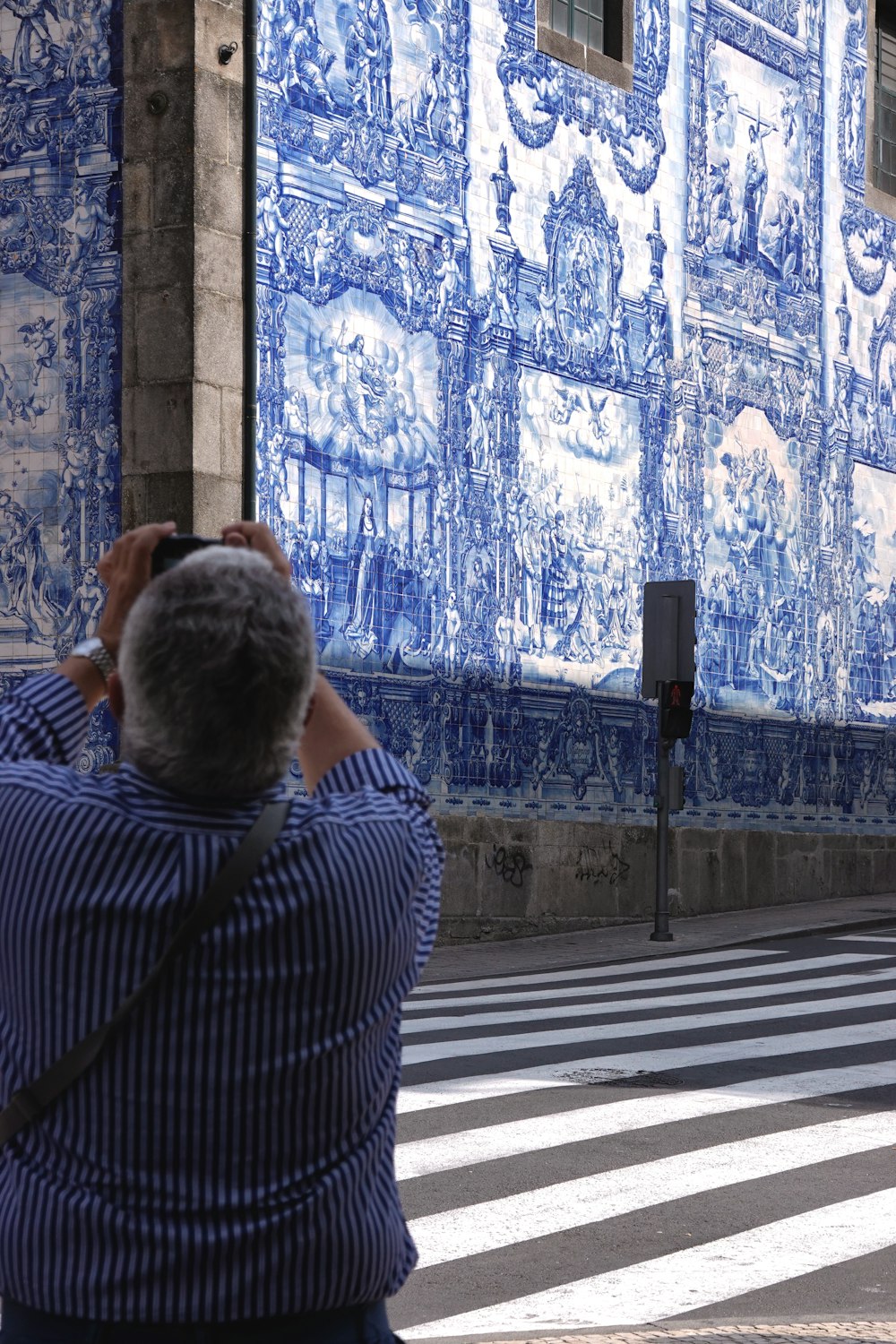 homme en chemise à rayures noires et blanches assis sur un banc