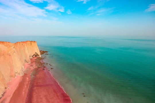 brown sand beside body of water during daytime in Hormuz Island Iran