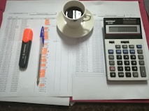 A serene workspace with a calculator, coffee, and a stack of financial books.