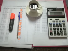 Office desk with accounting documents, calculator, and laptop.