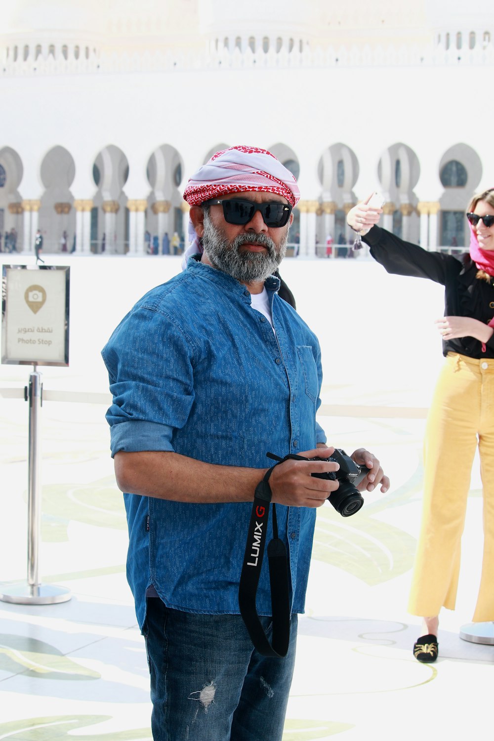 man in blue button up shirt holding black dslr camera