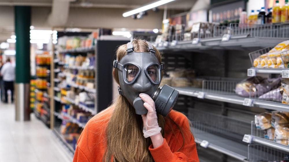 woman in red long sleeve shirt wearing black gas mask