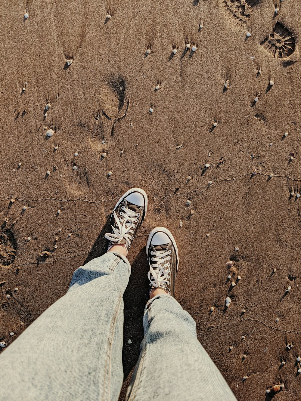 person in blue denim jeans and white sneakers