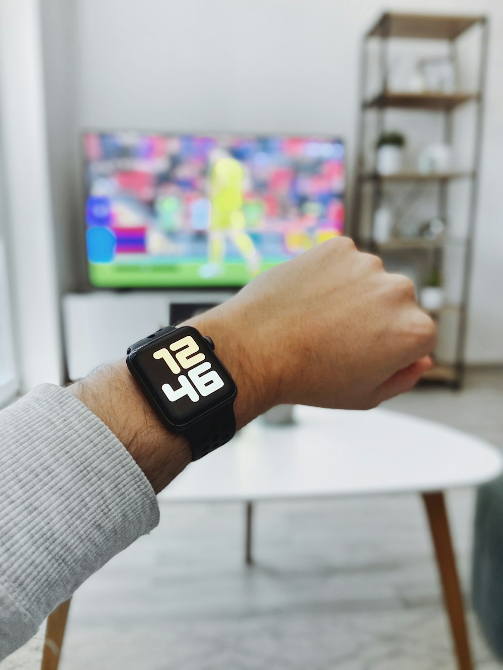 a person wearing a smart watch in front of a television
