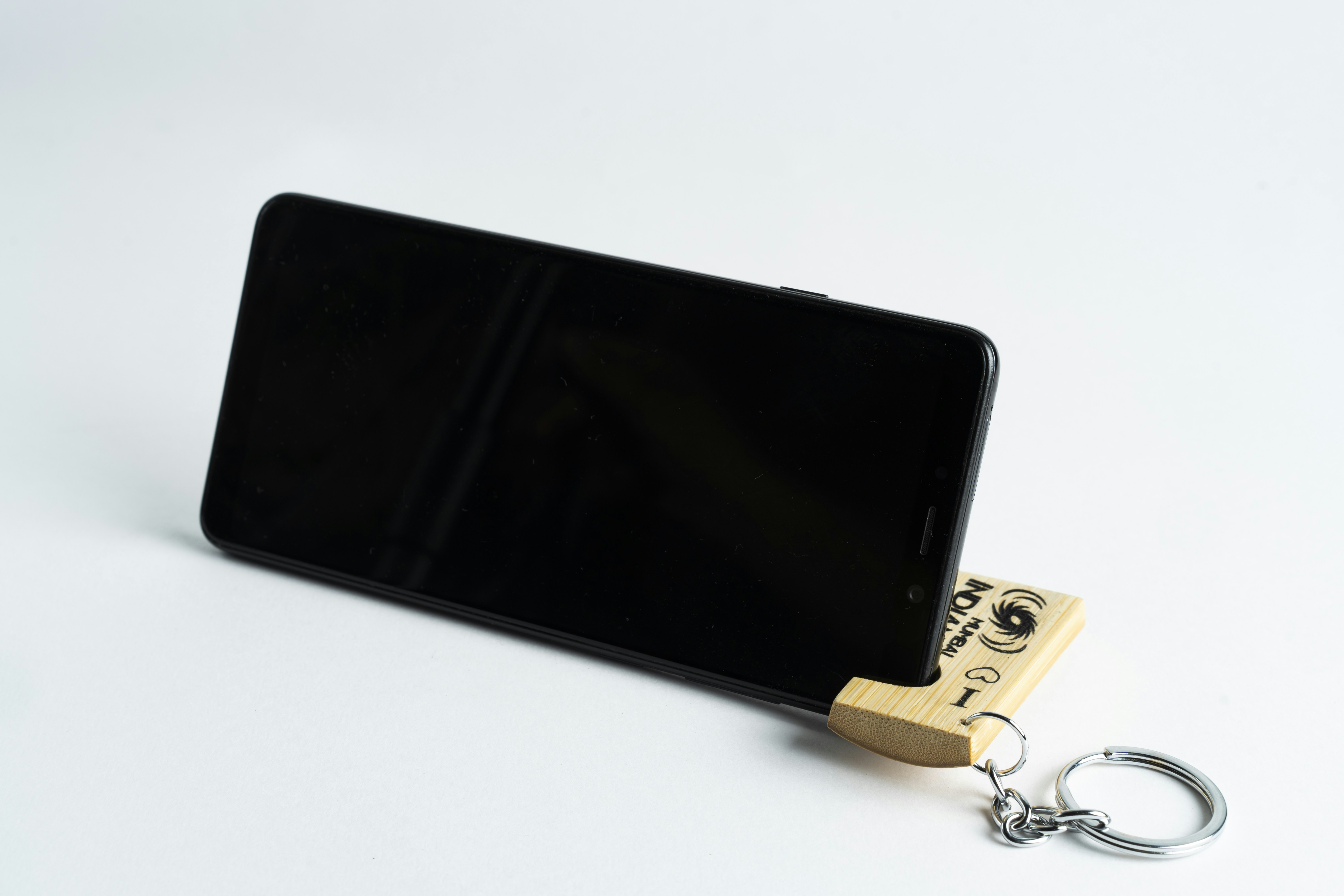 black android smartphone beside gold key