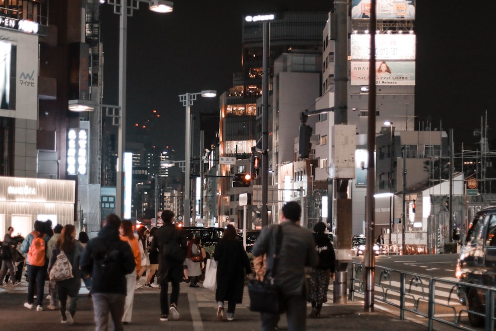 people walking on sidewalk during night time