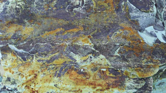 Rough rare mineral specimens with rich earthy textures on a neutral background